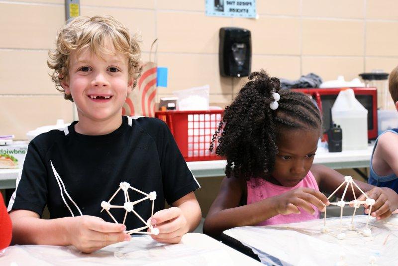 Two students build structures out of marshmallows 和 toothpicks